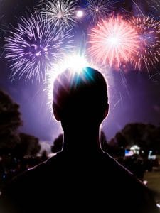 silhouette of a person watching fireworks 