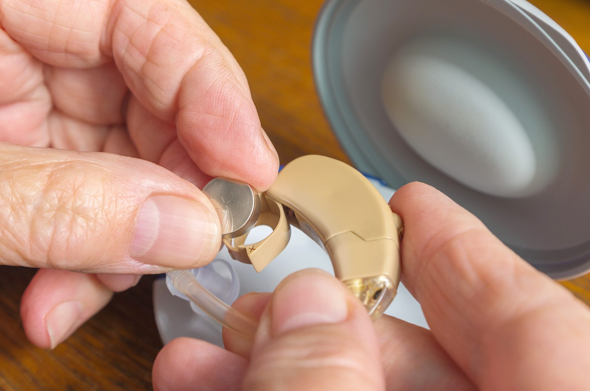 Close up of a woman changing her hearing aid battery.
