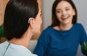 Young women with hearing aids has a pleasant conversation with a friend.