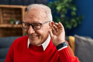 Senior man looking happy with his new hearing aid.