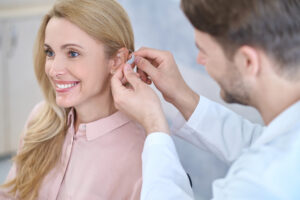 Woman gets behind the ear hearing aid placed