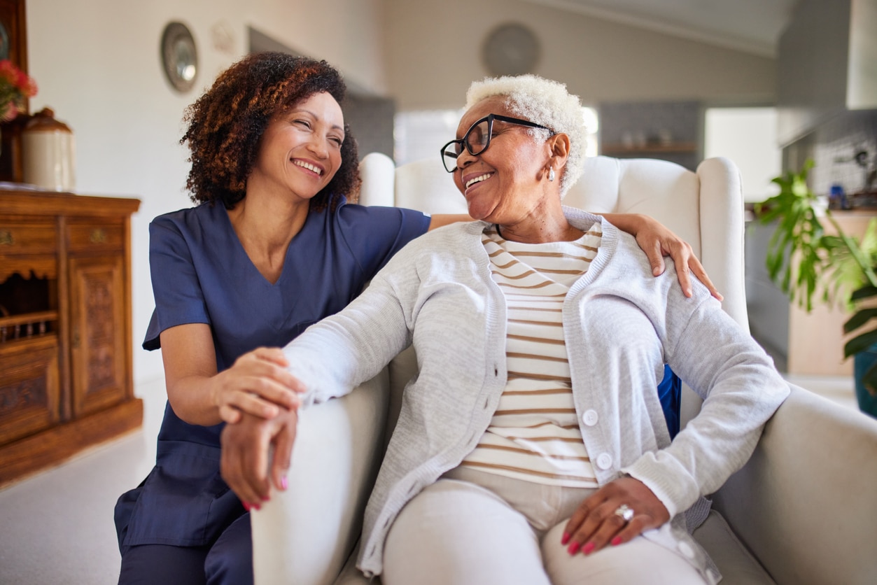 Caregiver smiling with a senior woman.